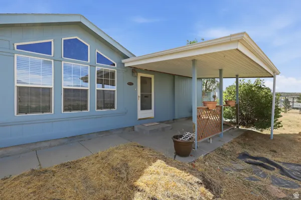Exterior featuring a covered porch entry, multiple window styles, and light blue siding