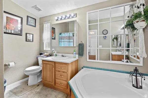 Bathroom featuring a built-in soaking tub with teal tile surround