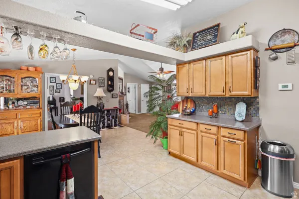 Kitchen featuring wood cabinetry, a mosaic tile backsplash, and a built-in dishwasher
