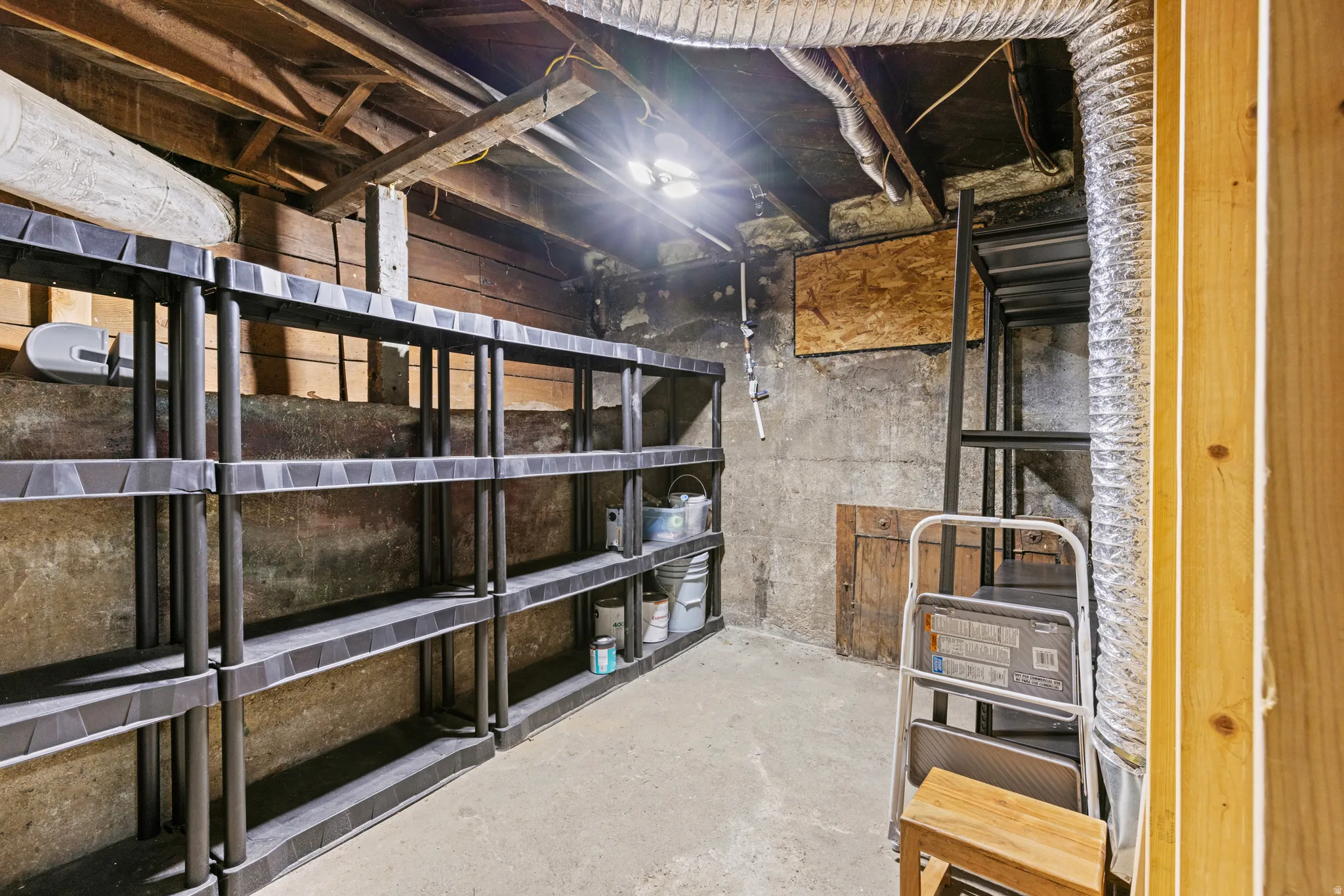 Concrete flooring with exposed ceiling joists and visible ductwork
