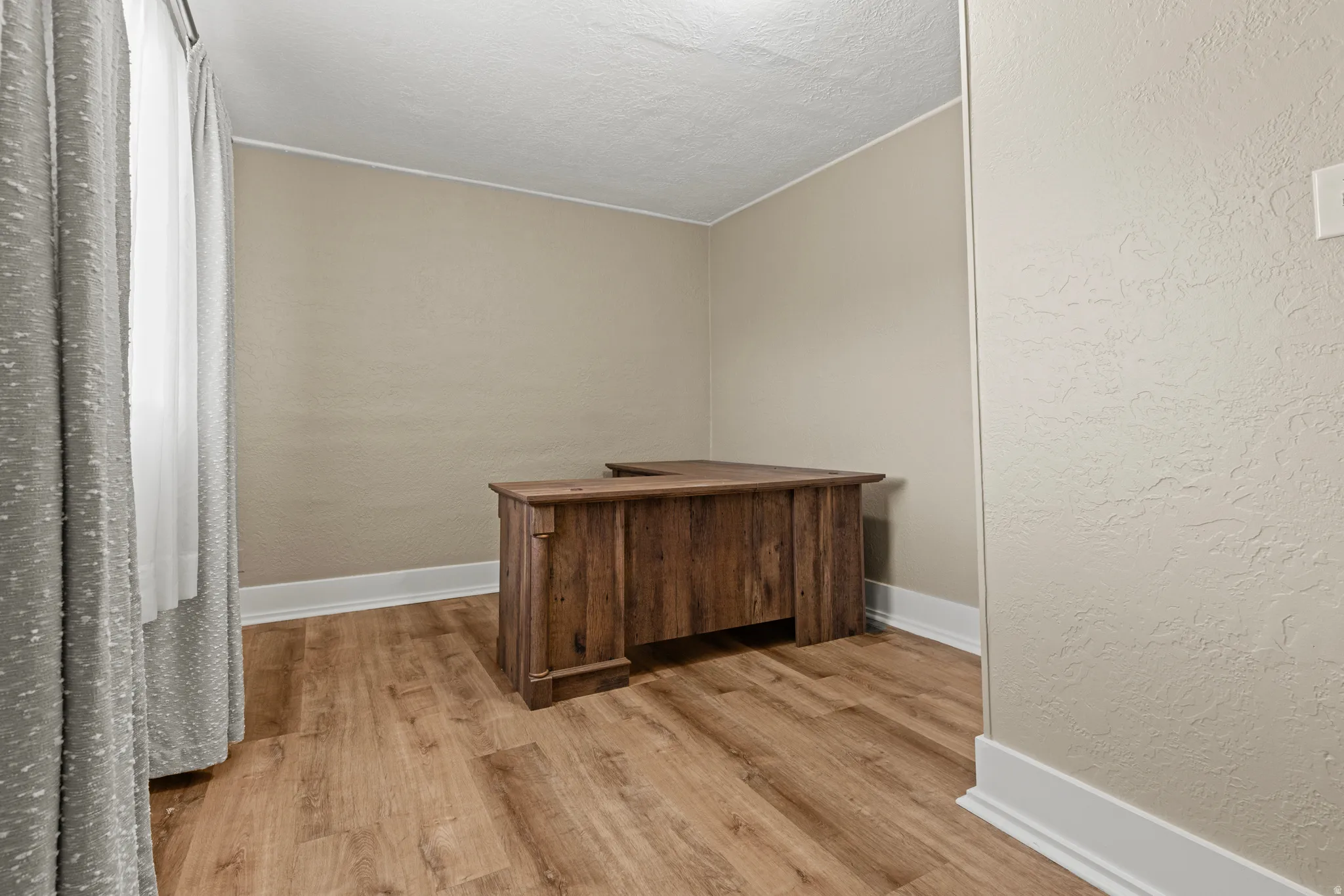 Room featuring wood-finish flooring and neutral wall tones