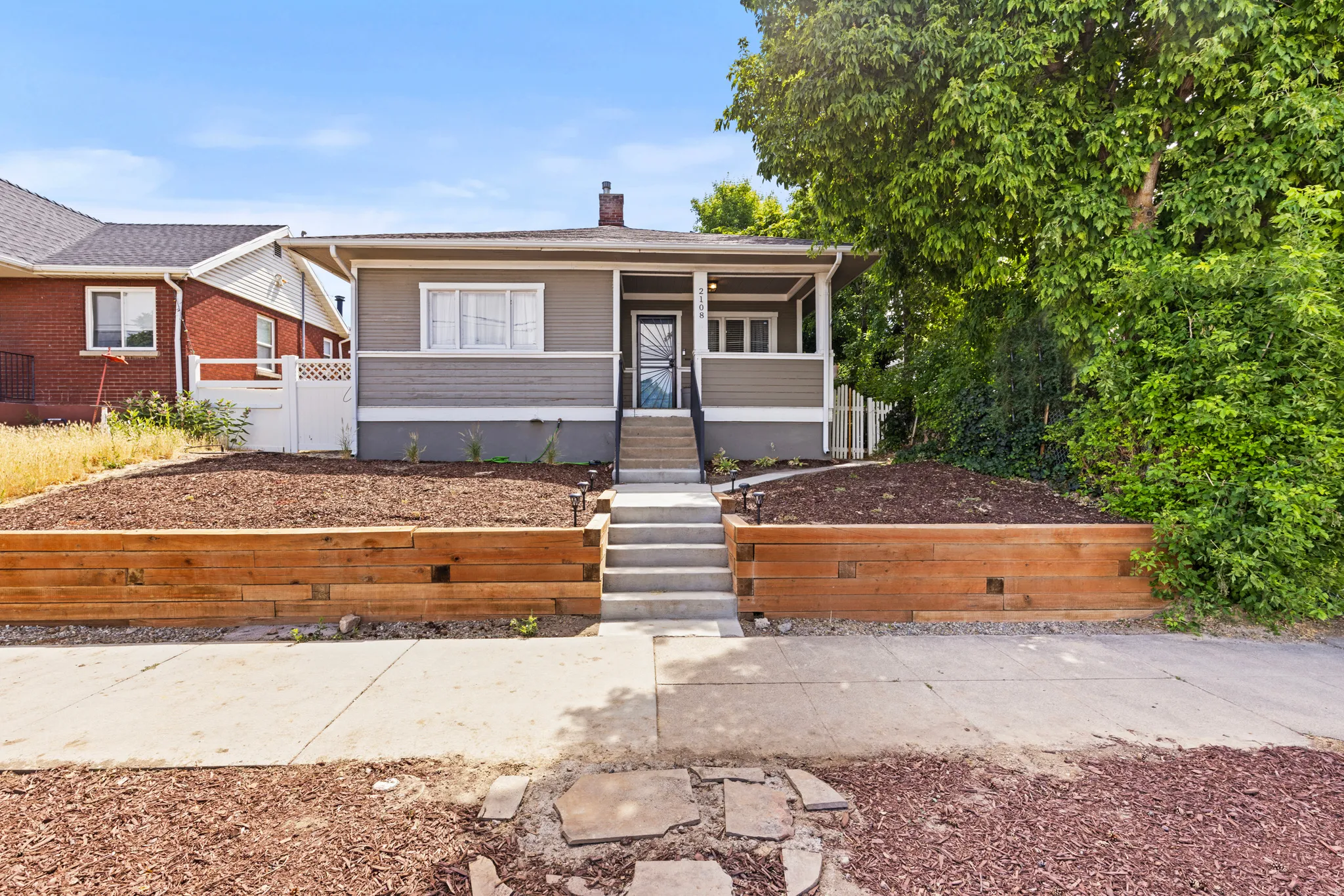 Single-story residence featuring a covered front porch, wood-look horizontal siding, and a contrasting foundation
