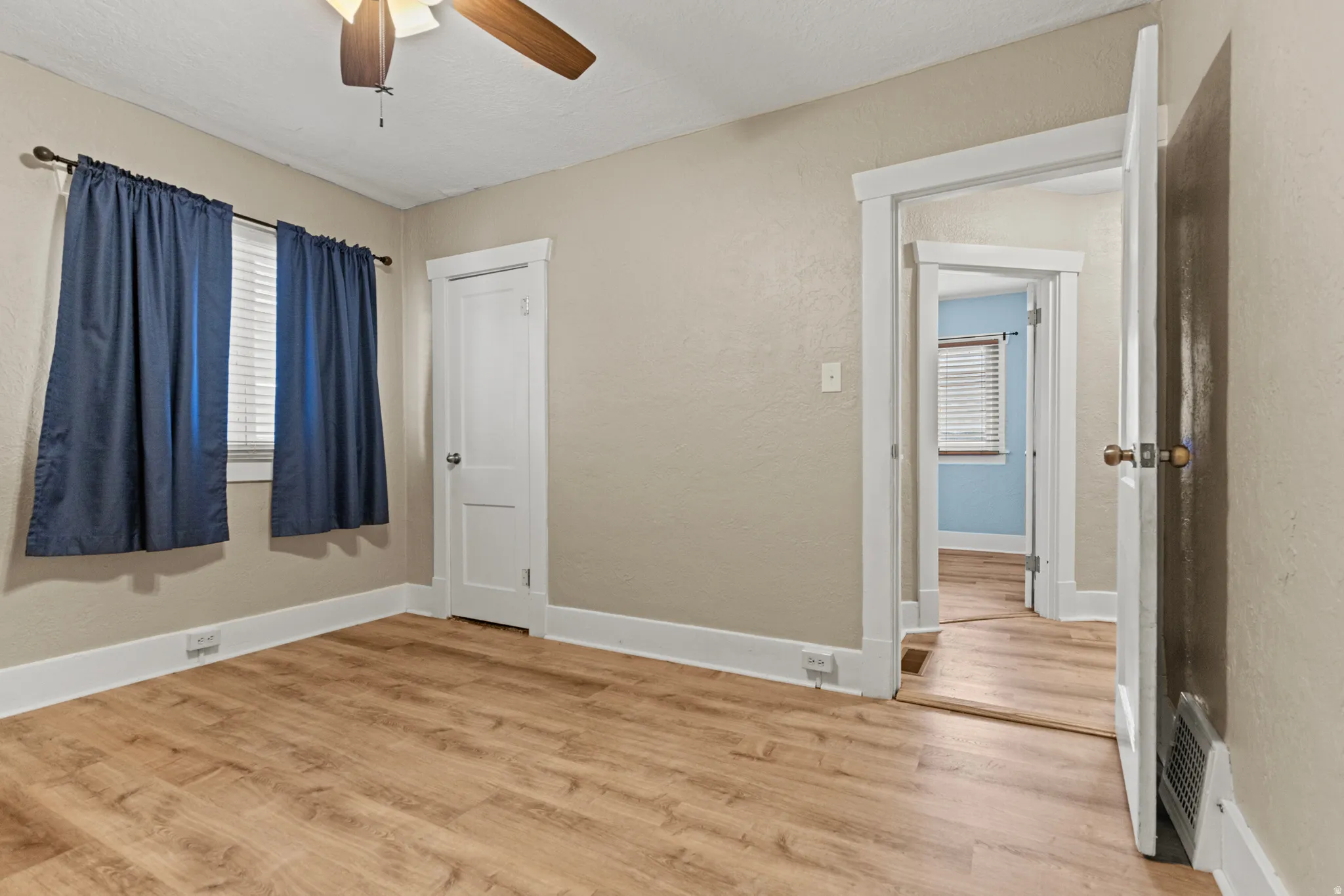 Interior room featuring wood-finish flooring, neutral wall tones, and white trim