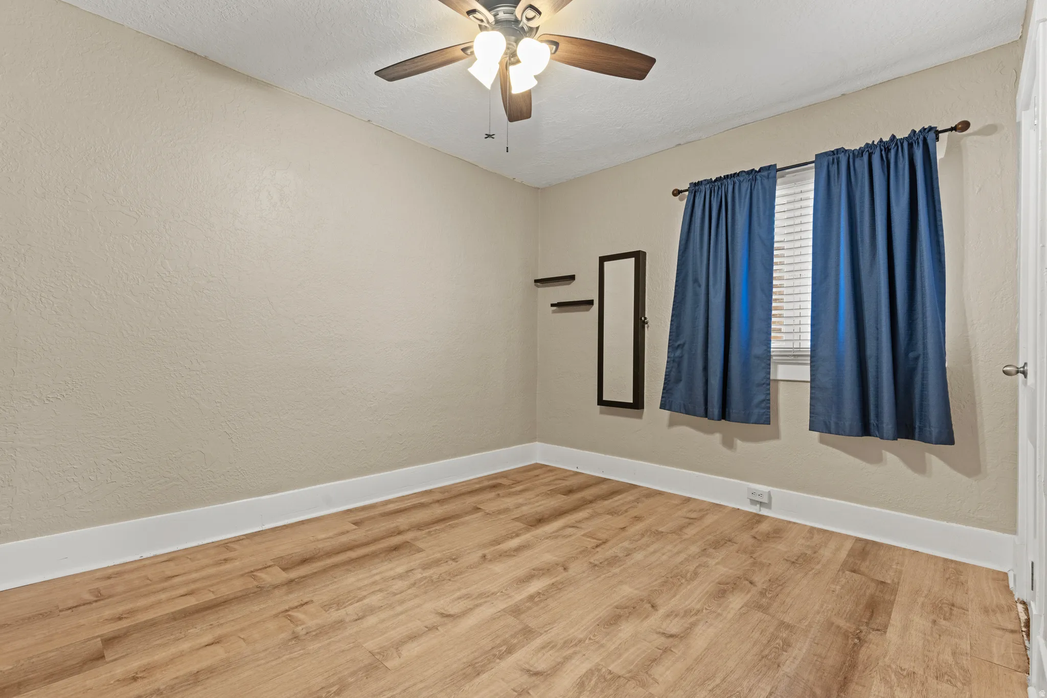 Light-toned walls with contrasting white trim and wood-finish flooring