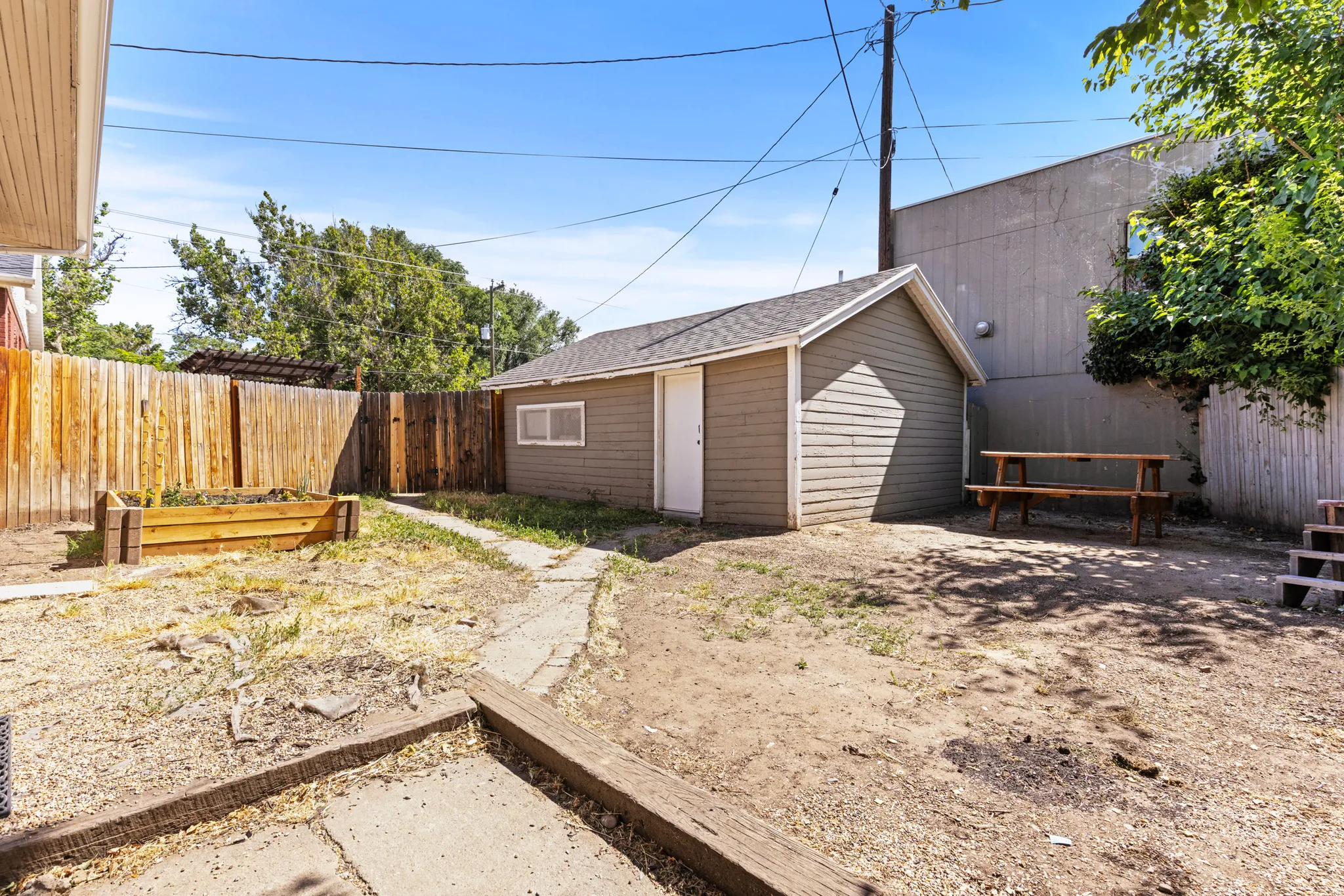 Private backyard with a detached shed, wood privacy fencing, and concrete patio areas