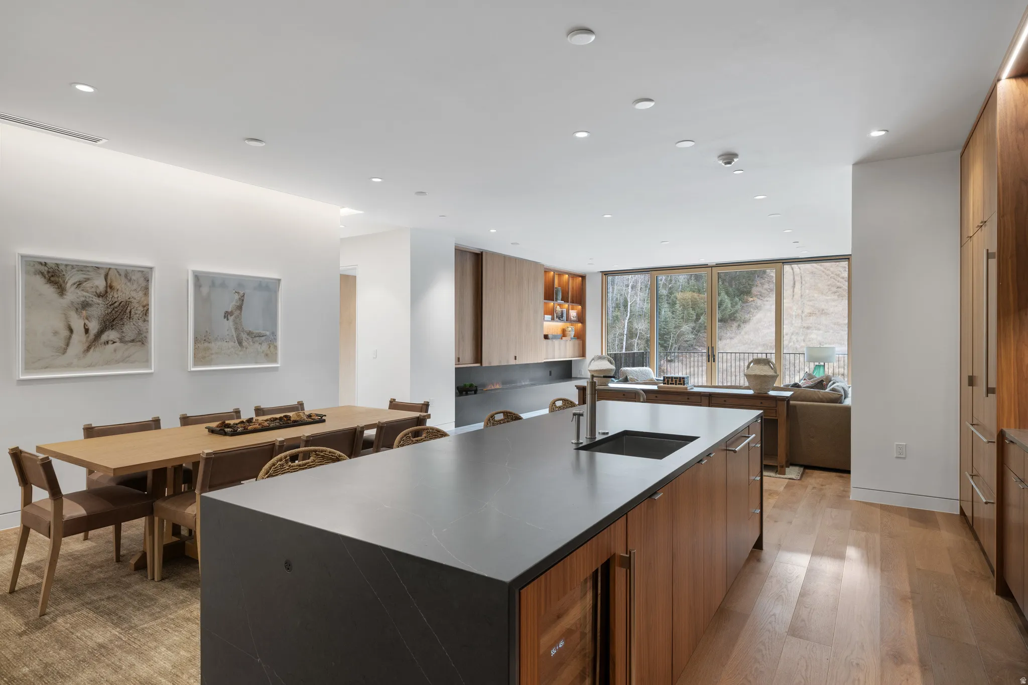 Contemporary kitchen island featuring a deep undermount sink, integrated beverage cooler, and dark stone countertop