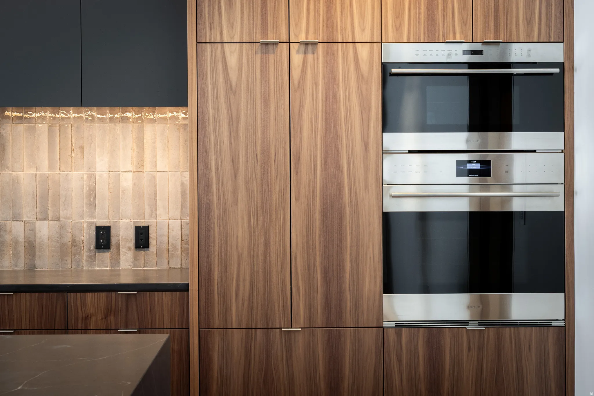Integrated stainless steel double oven, surrounded by vertical grain wood cabinetry