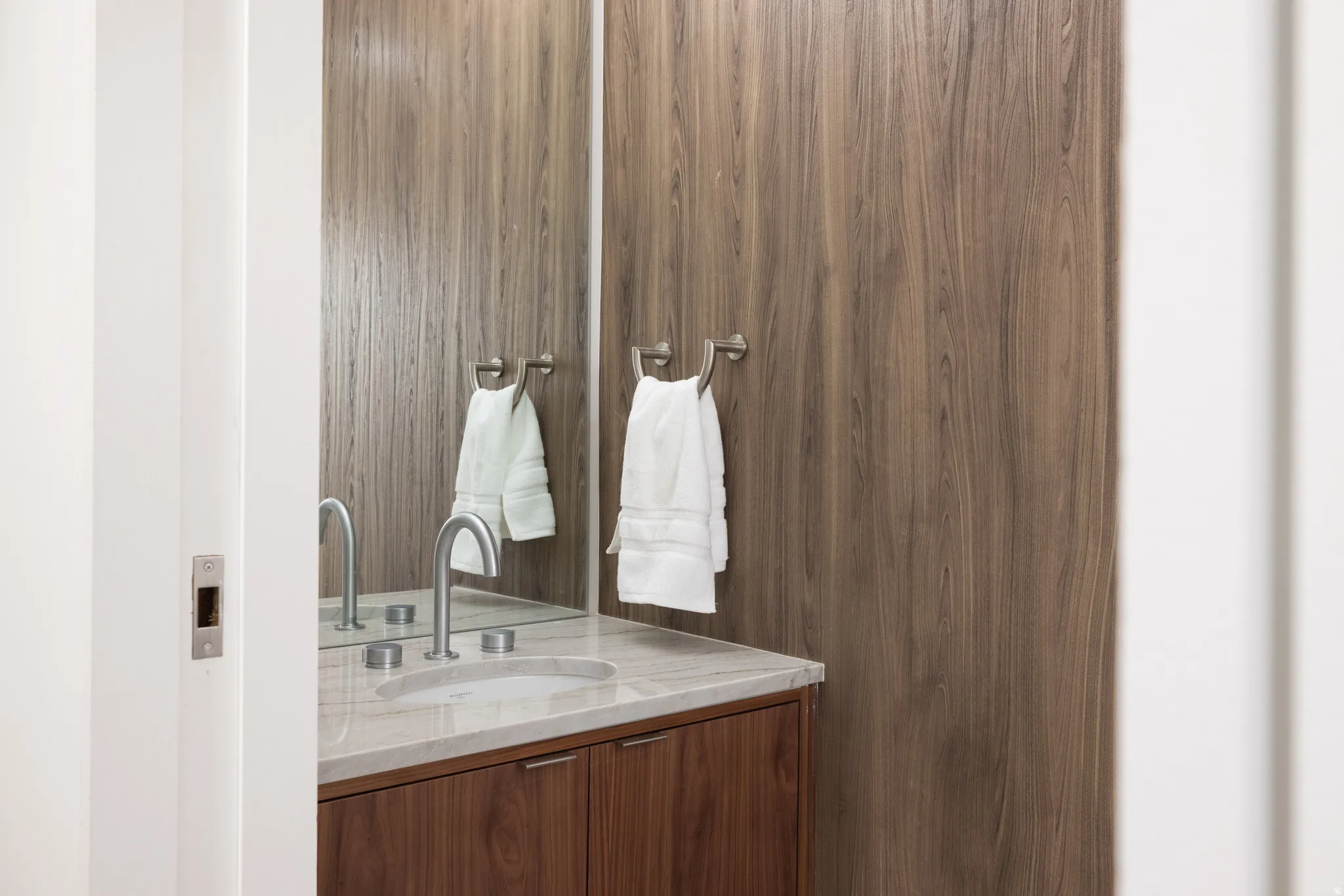 Vanity with a wood-finish cabinet, integrated sink, and brushed nickel faucet