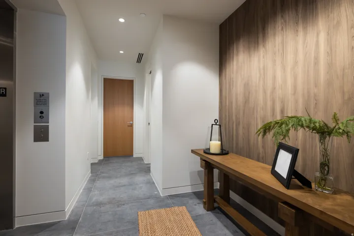 Entryway featuring a wood-panel accent wall, recessed lighting, and large format tile flooring