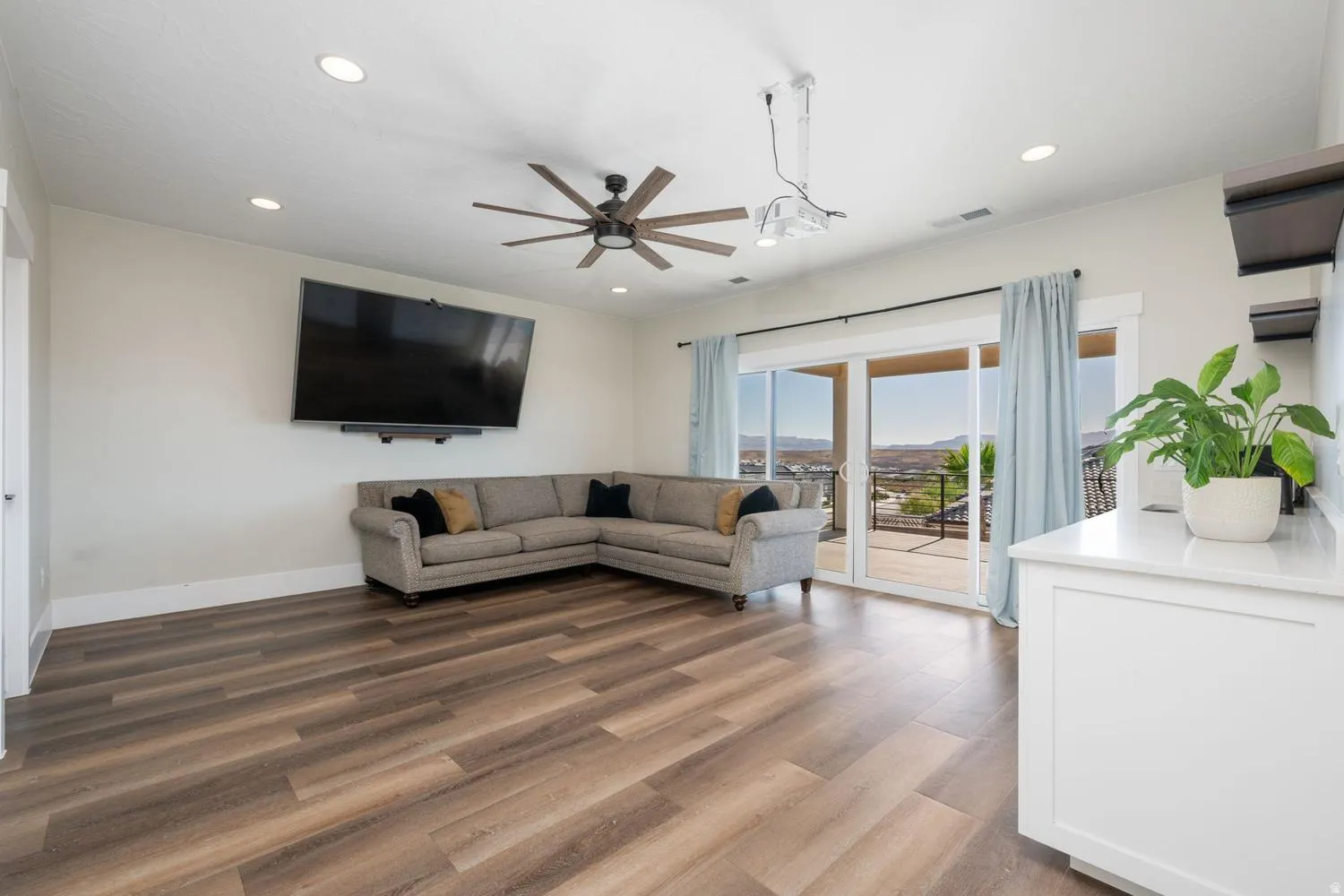 Spacious room featuring wood-finish flooring, recessed lighting, and a ceiling fan