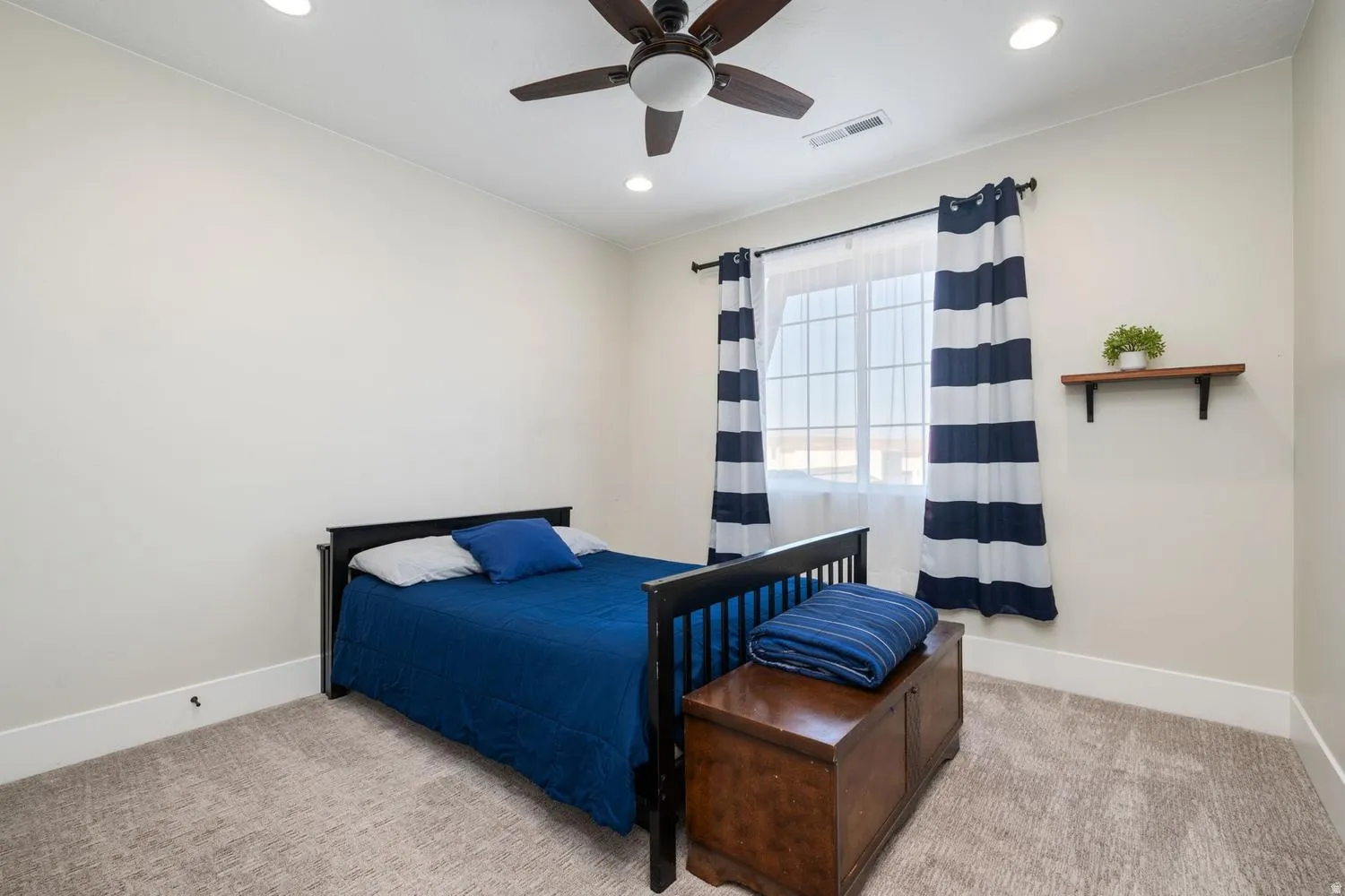 Bedroom featuring a ceiling fan, recessed lighting, carpet flooring, a window with vertical blinds, and a wall-mounted shelf