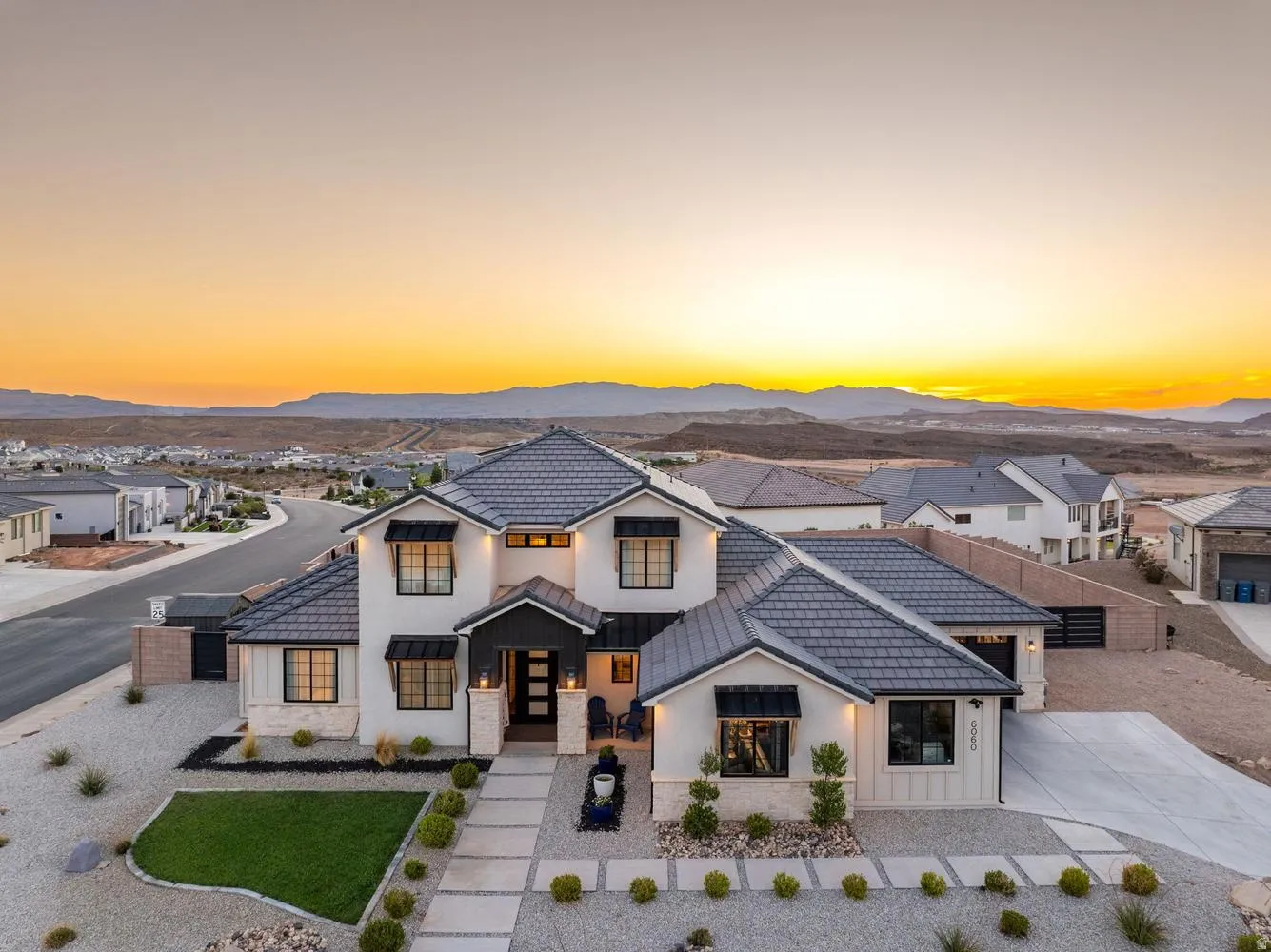 Contemporary home featuring a light-colored exterior with dark trim and a multi-gabled roof