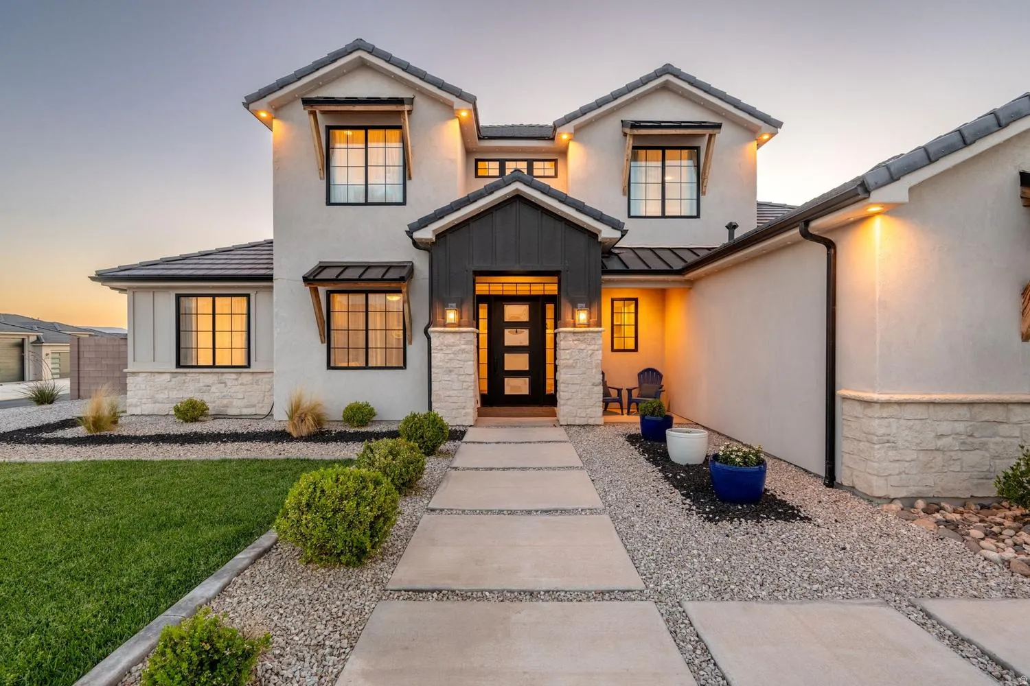 Modern stucco exterior with dark trim accents and stacked stone detailing