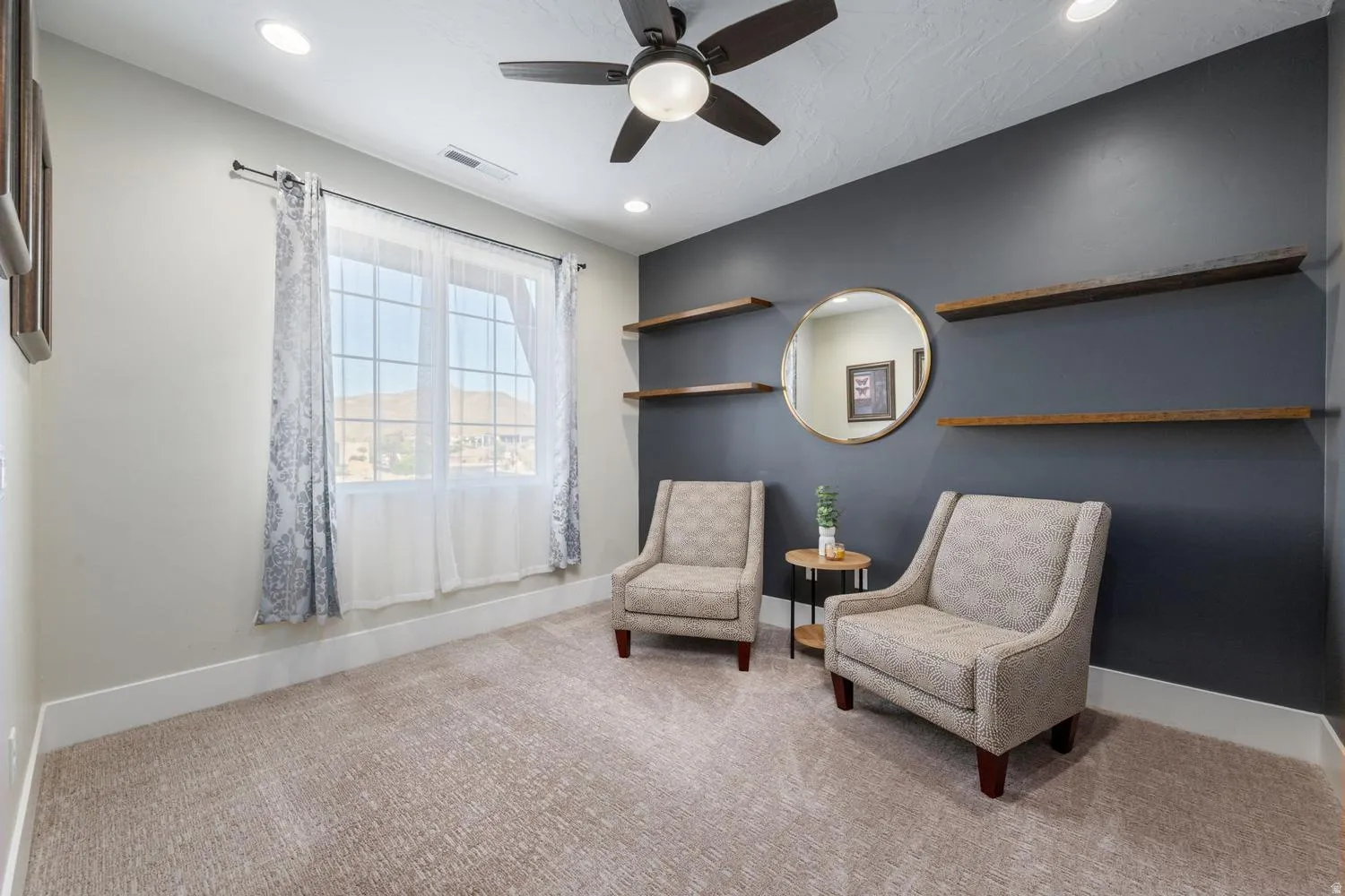 Room featuring recessed lighting, a ceiling fan, a window with exterior mountain scenery, and built-in wood-finish shelving