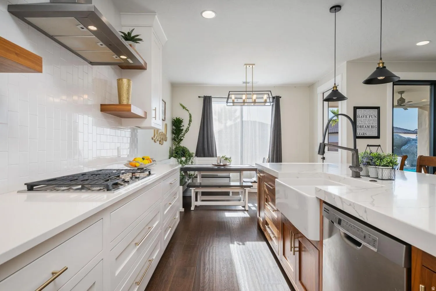 Gourmet kitchen featuring a gas cooktop, white subway tile backsplash, white shaker cabinetry, an apron-front sink, and stainless steel appliances