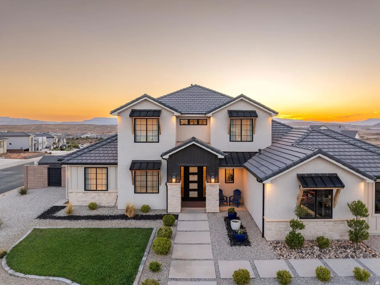Modern stucco exterior with dark tile roofing and stone accents