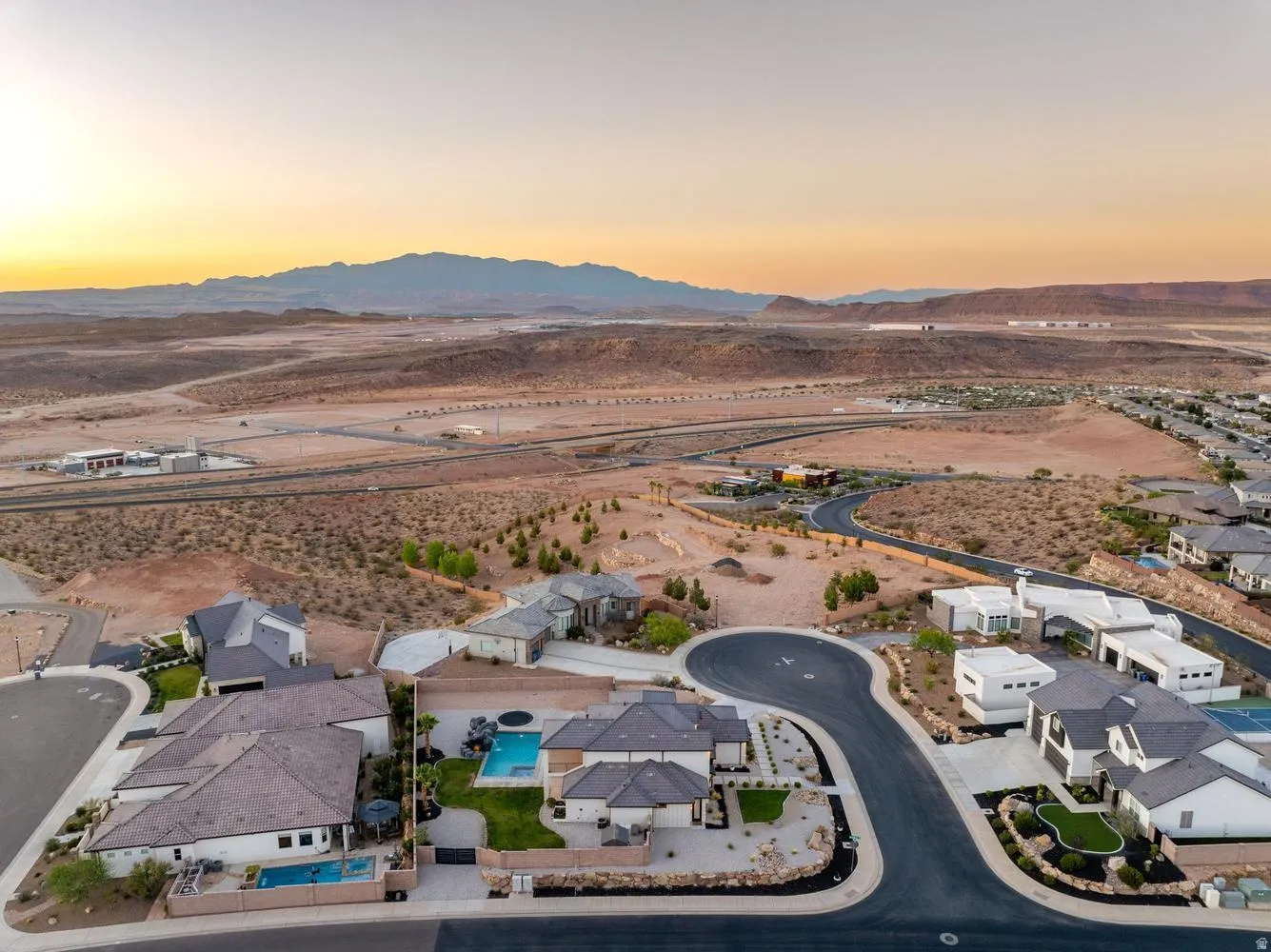 Aerial perspective showcasing a residential cul-de-sac with properties featuring private pools and structured landscaping