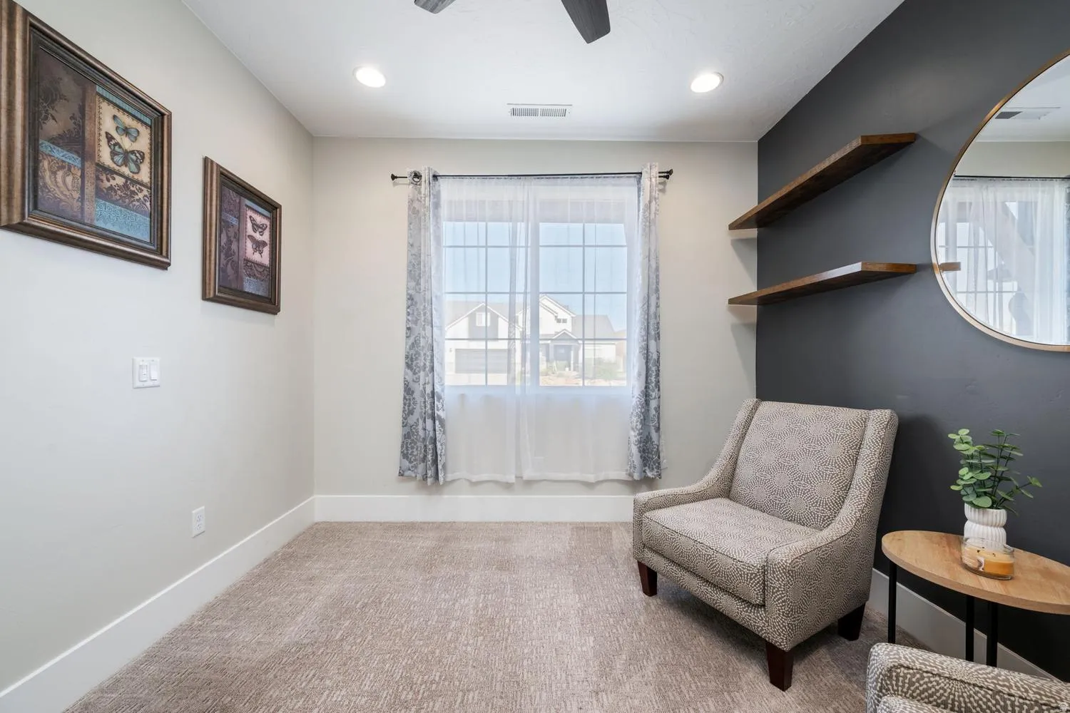 Carpeted room featuring a large window with sheer and patterned curtains, recessed lighting, and a ceiling fan