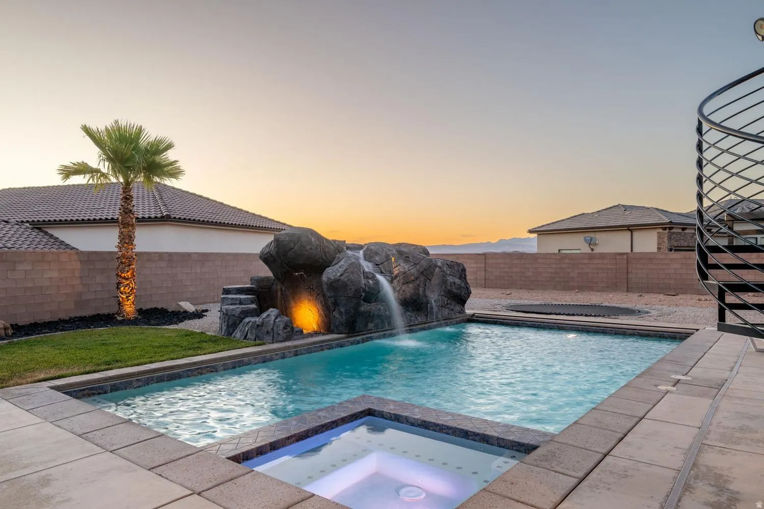 Resort-style pool with integrated spa and waterfall rock feature