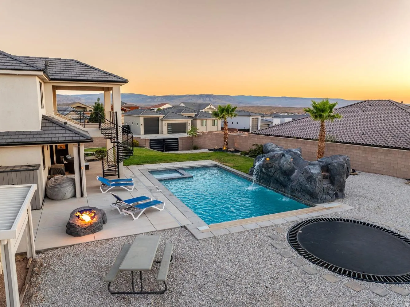 Backyard oasis featuring a swimming pool with integrated spa and rock waterfall