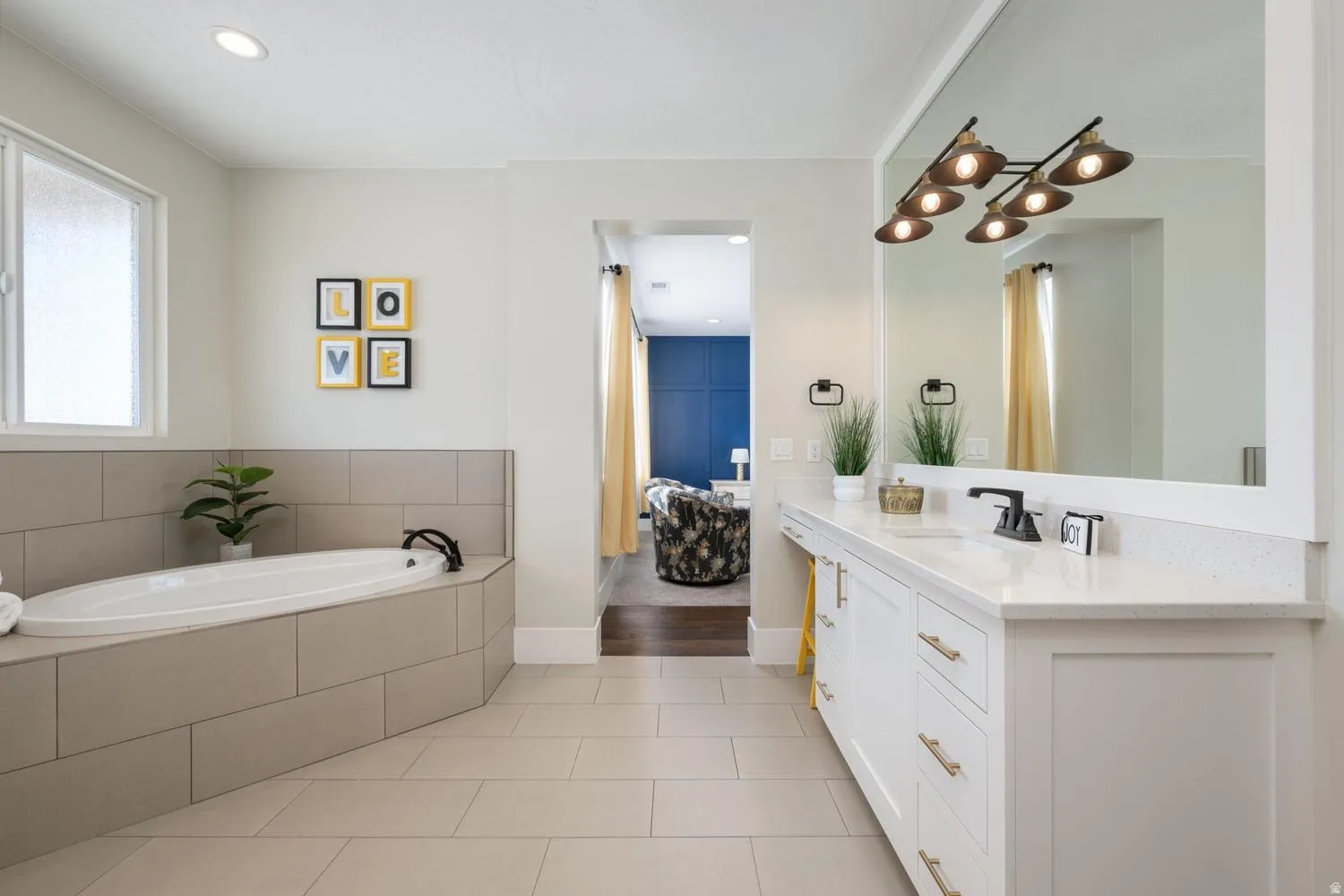 Contemporary bathroom featuring a built-in soaking tub, a dual vanity with a quartz countertop, and a large wall-mounted mirror