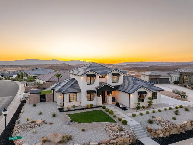 Contemporary two-story residence featuring a white stucco exterior with black trim accents and a dark tile roof