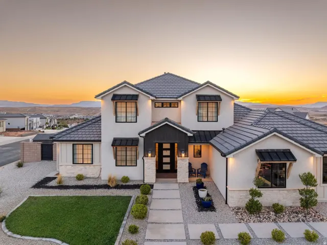 Modern stucco exterior with dark tile roofing and stone accents