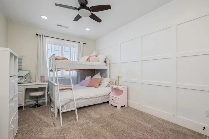 Carpeted interior space featuring a grid accent wall, a window with natural light, recessed lighting, and a ceiling fan