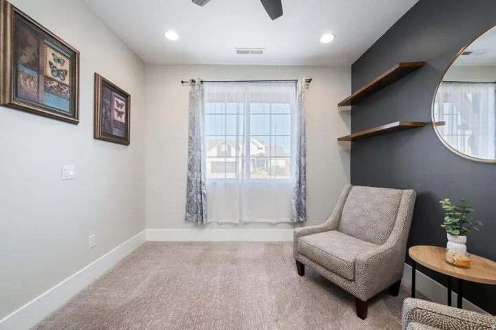 Carpeted room featuring a large window with sheer and patterned curtains, recessed lighting, and a ceiling fan