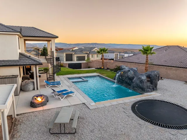 Backyard oasis featuring a swimming pool with integrated spa and rock waterfall