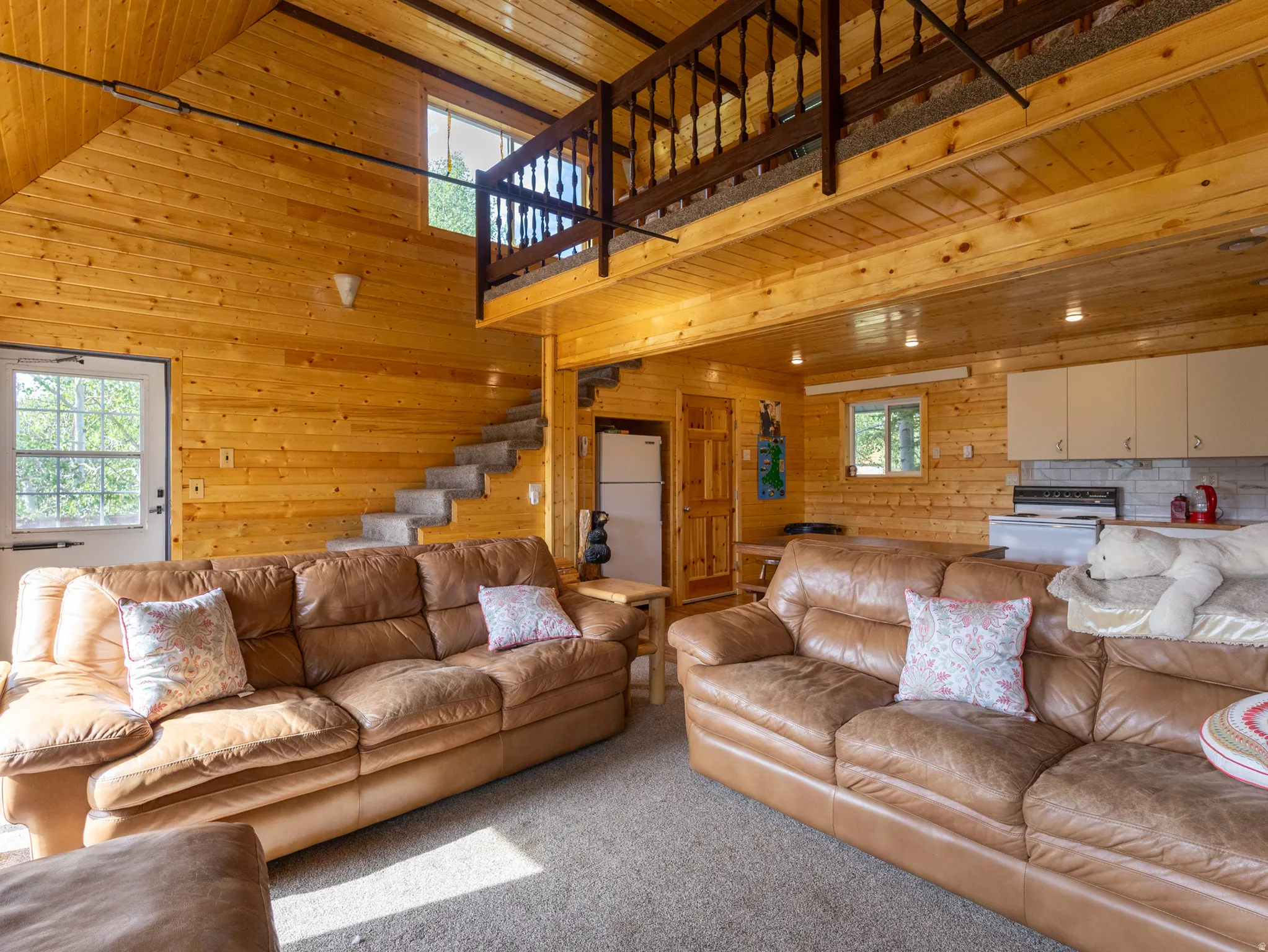Open-concept living space with extensive wood paneling throughout