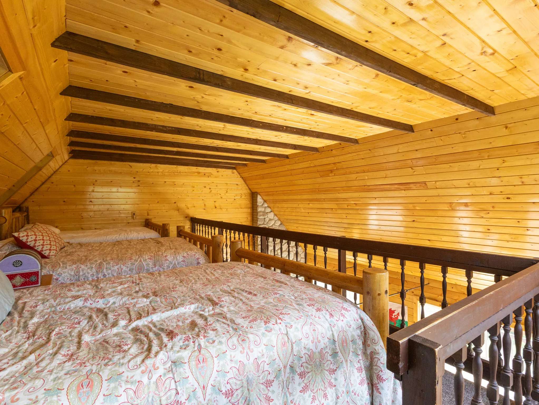 Exposed wood beam ceiling in a loft space with natural wood plank walls
