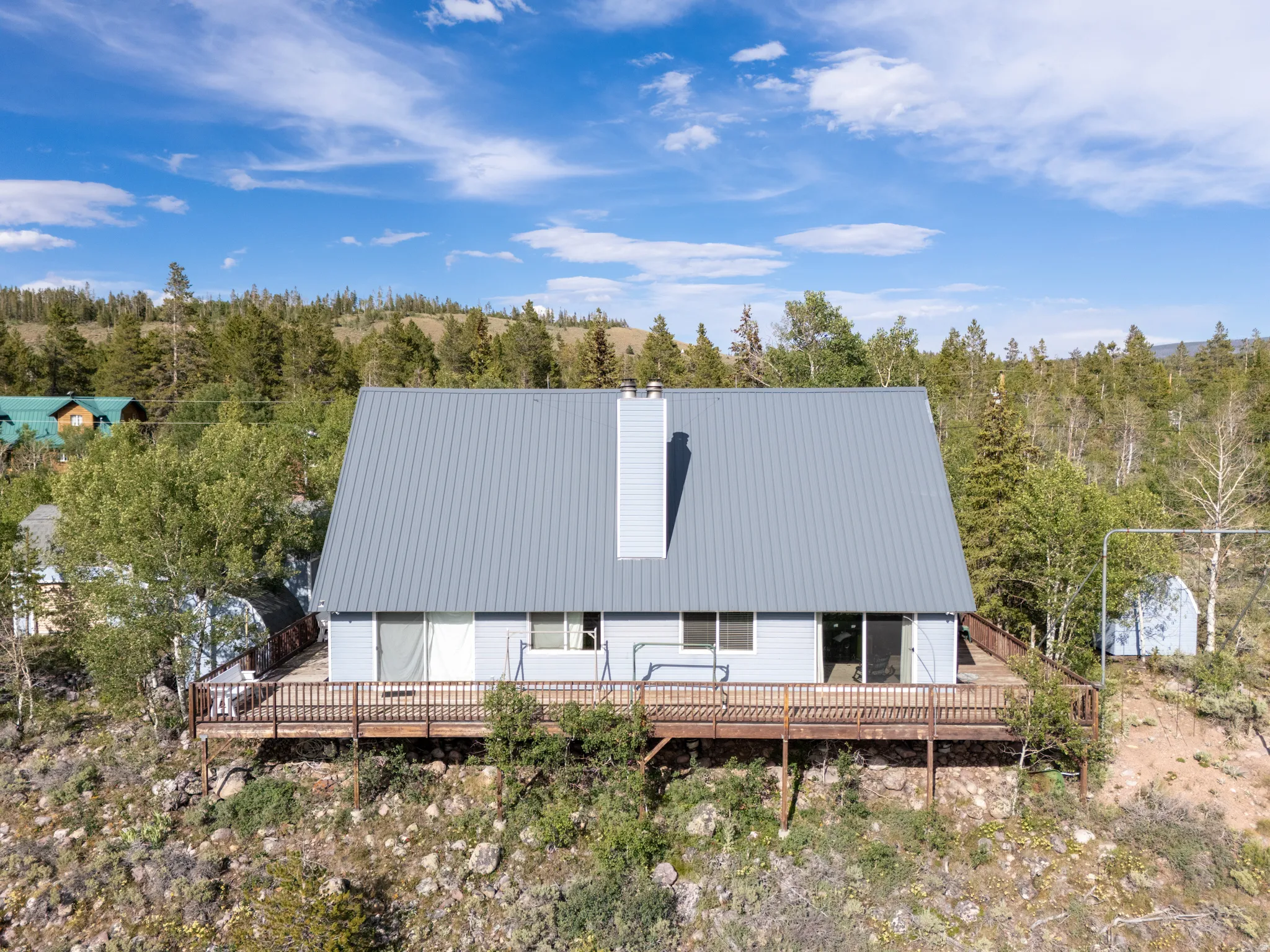 A-frame residence with a light blue exterior and a gray metal roof