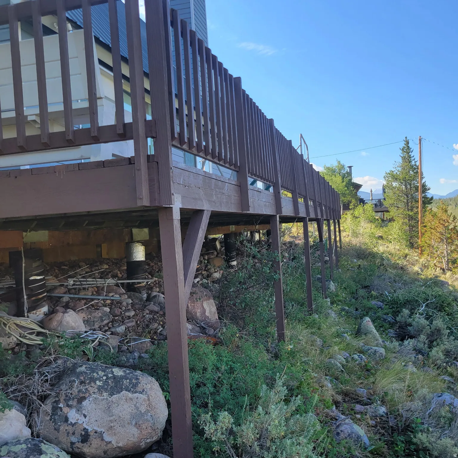 Expansive exterior deck featuring a wooden railing and visible support structure