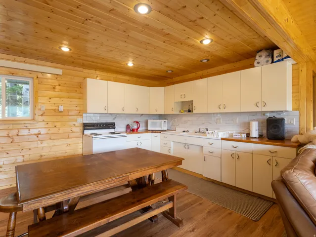 Kitchen area featuring wood paneling throughout, recessed lighting, and wood-finish flooring