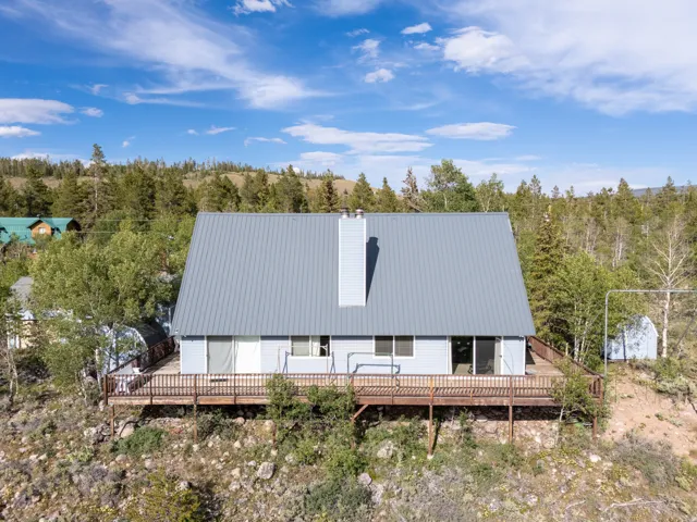 A-frame residence with a light blue exterior and a gray metal roof