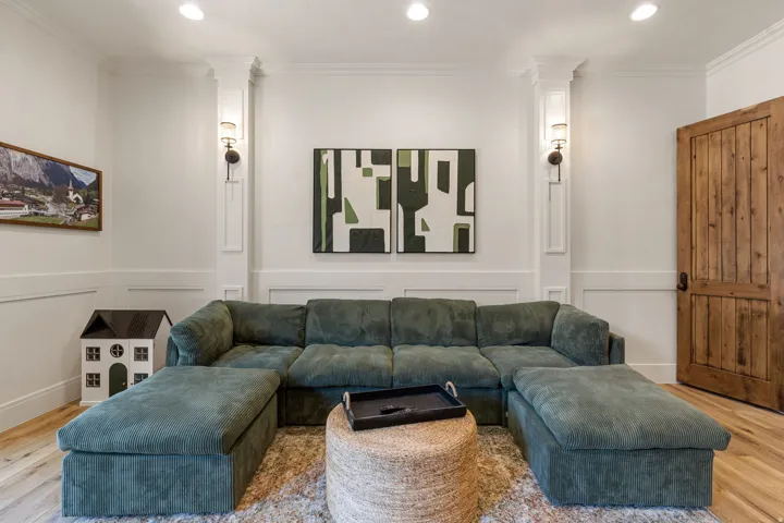 White paneled walls with sconce lighting and recessed ceiling lights