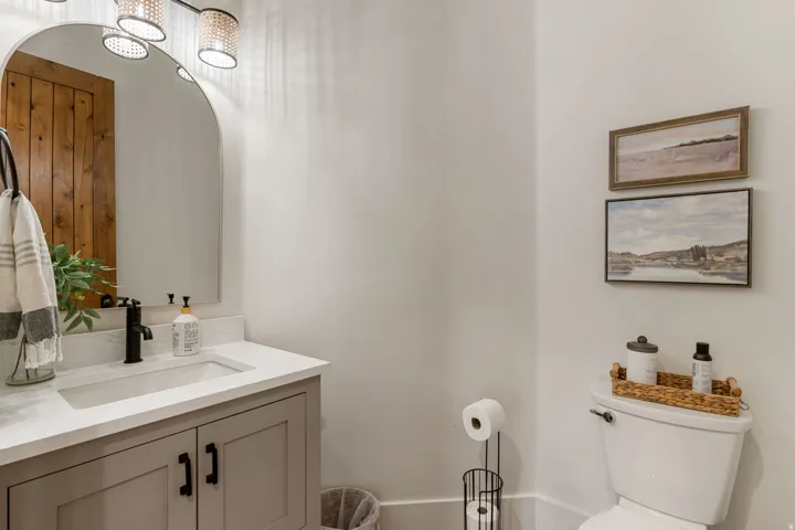 Bathroom featuring a white countertop with an undermount sink, a dark finished faucet, and cabinetry with dark hardware