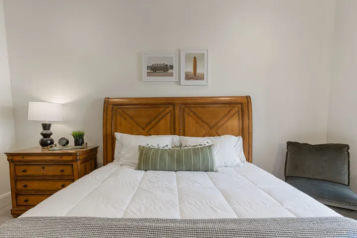 Light-toned wall finishes complement a wood-finish headboard with panel detailing
