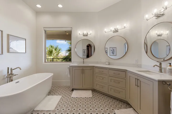 Freestanding soaking tub complemented by a double vanity with integrated sinks, quartz countertops, and brushed nickel fixtures