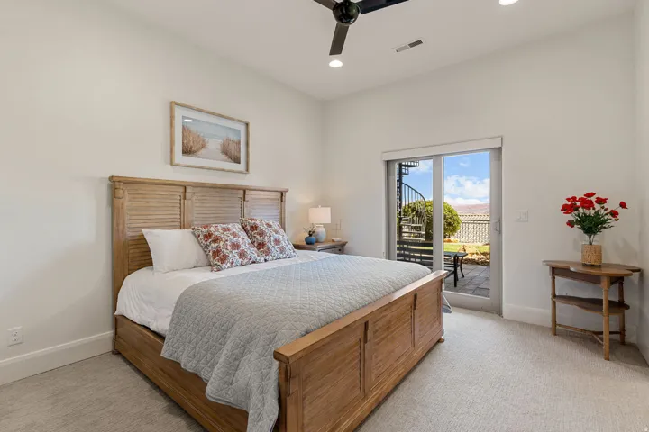 Carpeted bedroom featuring a ceiling fan with integrated lighting