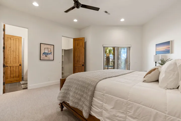 Carpeted room featuring a built-in ceiling fan with light, recessed lighting, and a sliding glass door leading to a balcony