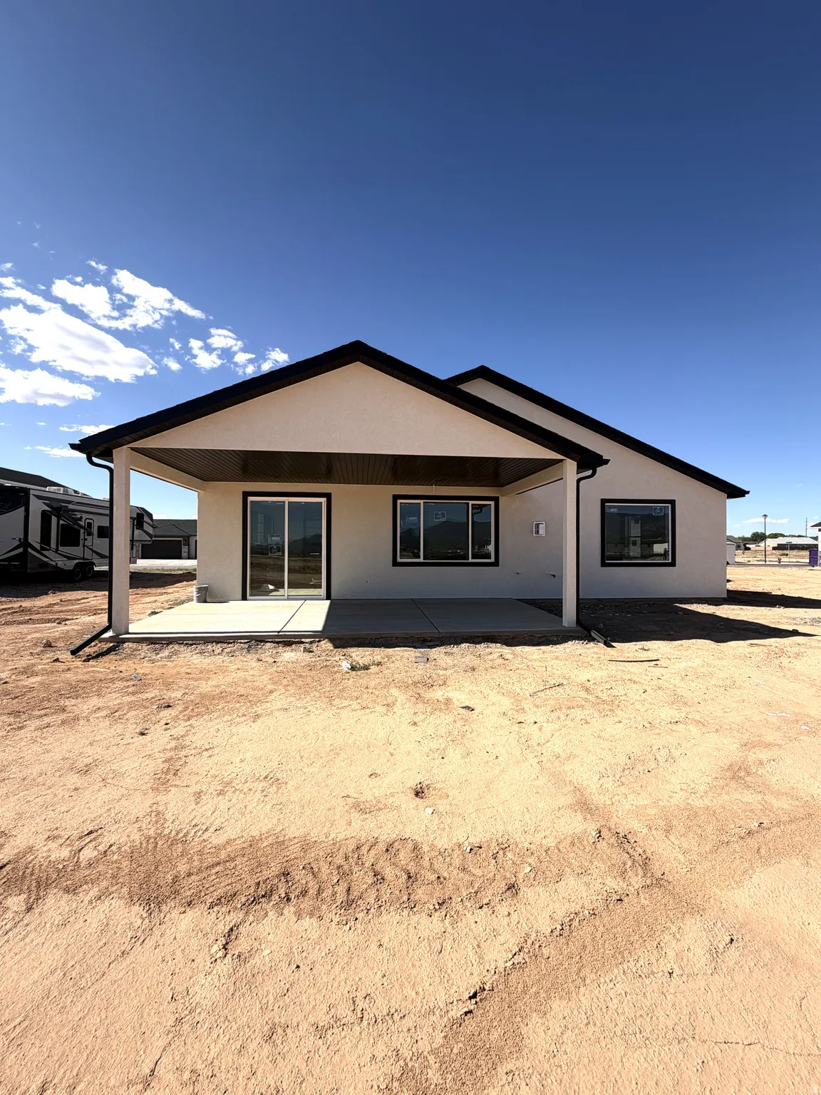 Contemporary stucco exterior with a covered concrete patio