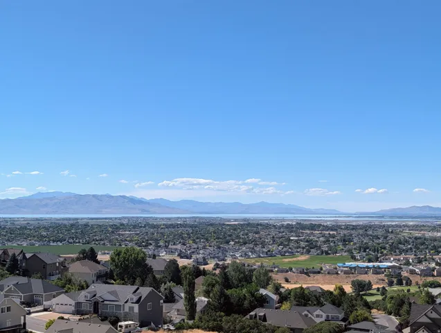 Expansive mountain backdrop with a visible body of water, offering broad landscape scenery
