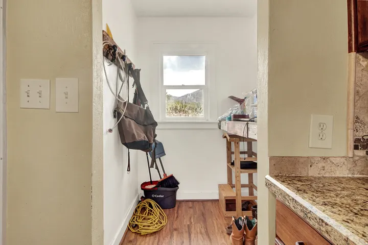 Utility area with wood-finish flooring, a double-hung window, and a built-in counter surface