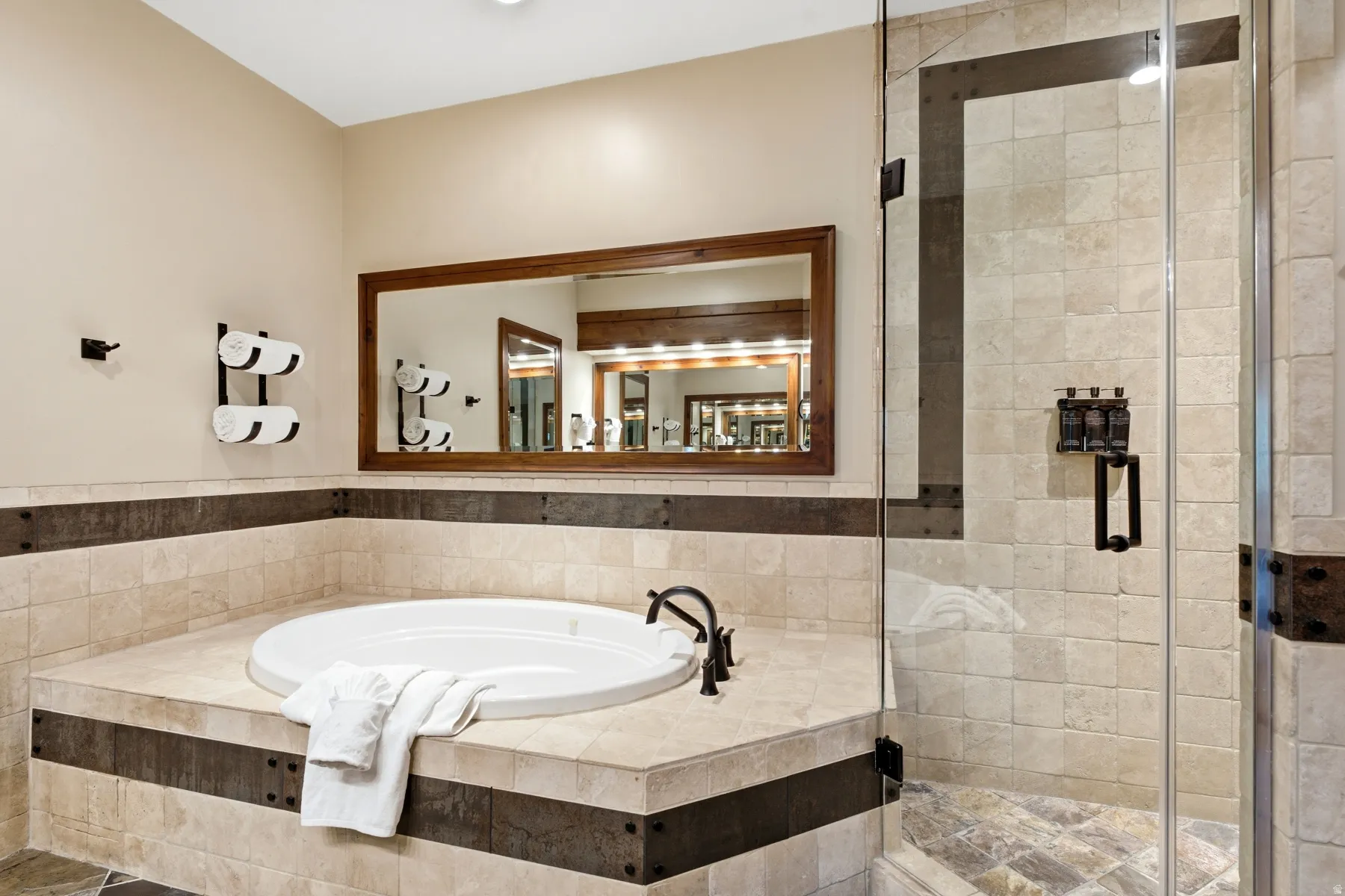 Soaking tub integrated into a tiled surround, complemented by a glass-enclosed shower with a tiled interior