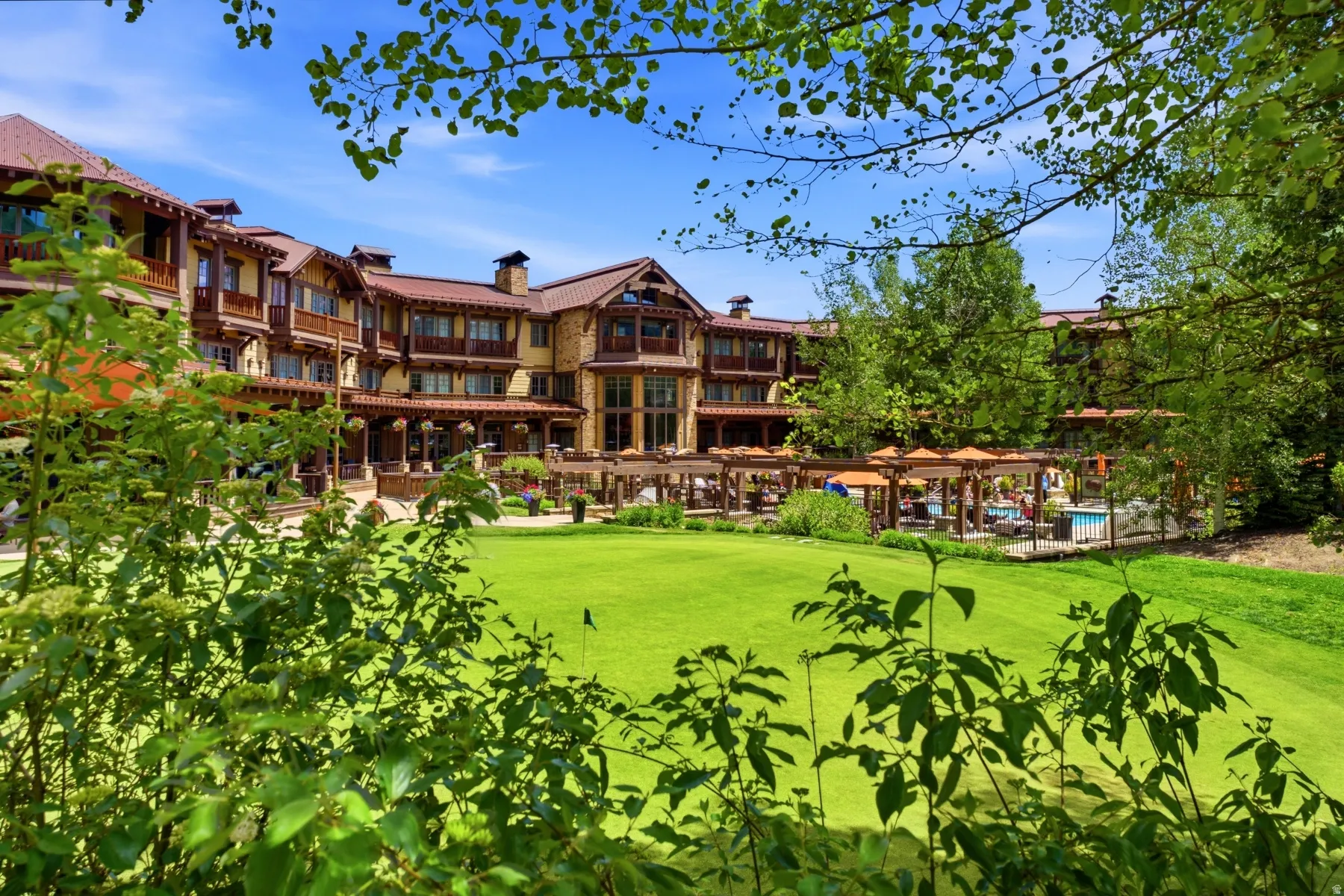 Expansive green lawn with a flag, framed by lush foliage