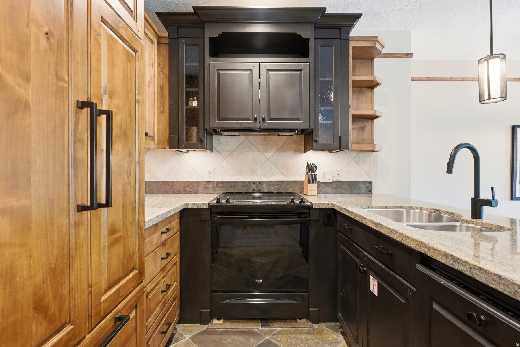 Kitchen featuring light wood-finish paneled appliances, dark wood-finish cabinetry, and granite countertops