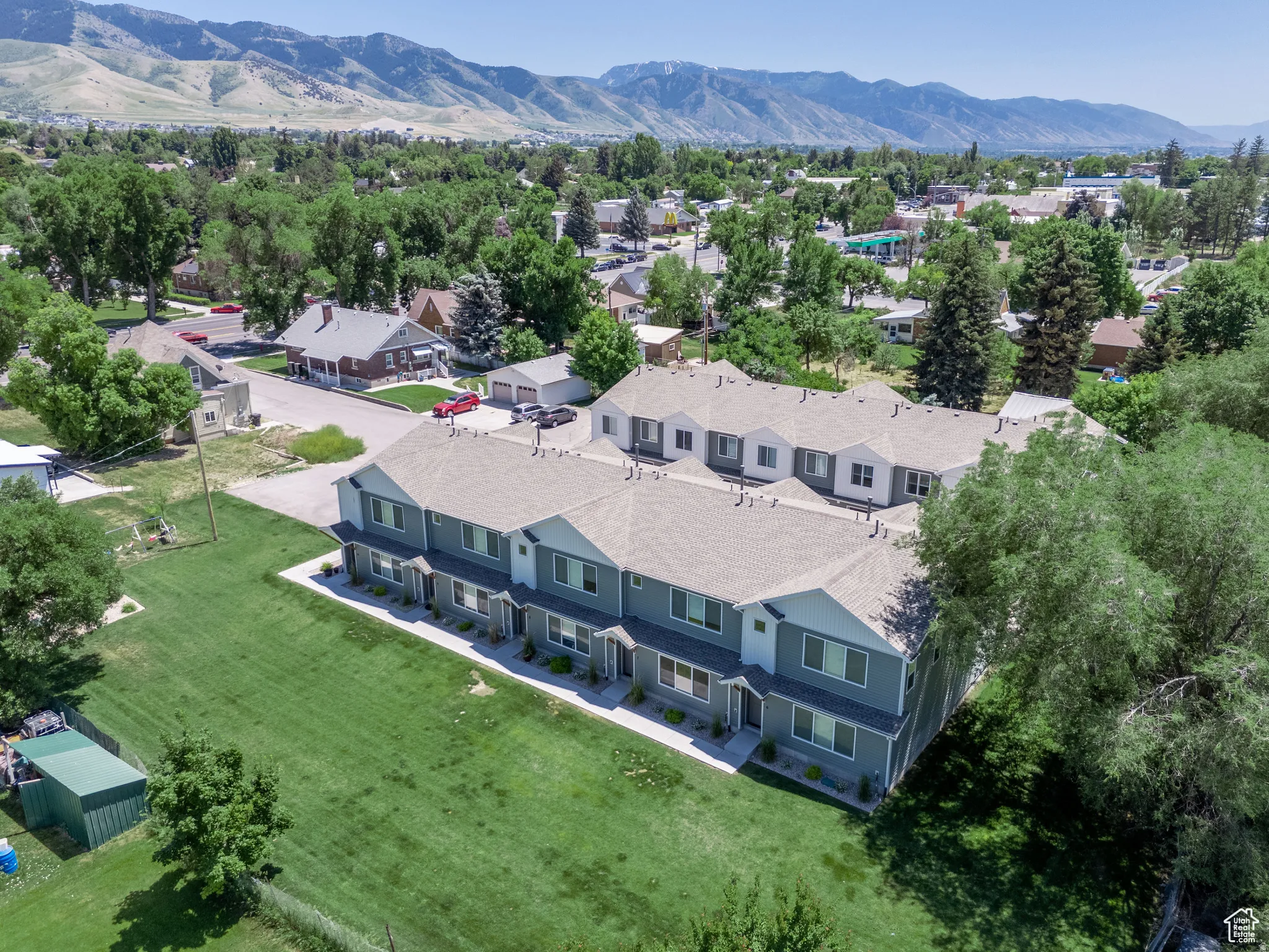 Modern townhome complex featuring multi-level units with gray siding and white trim