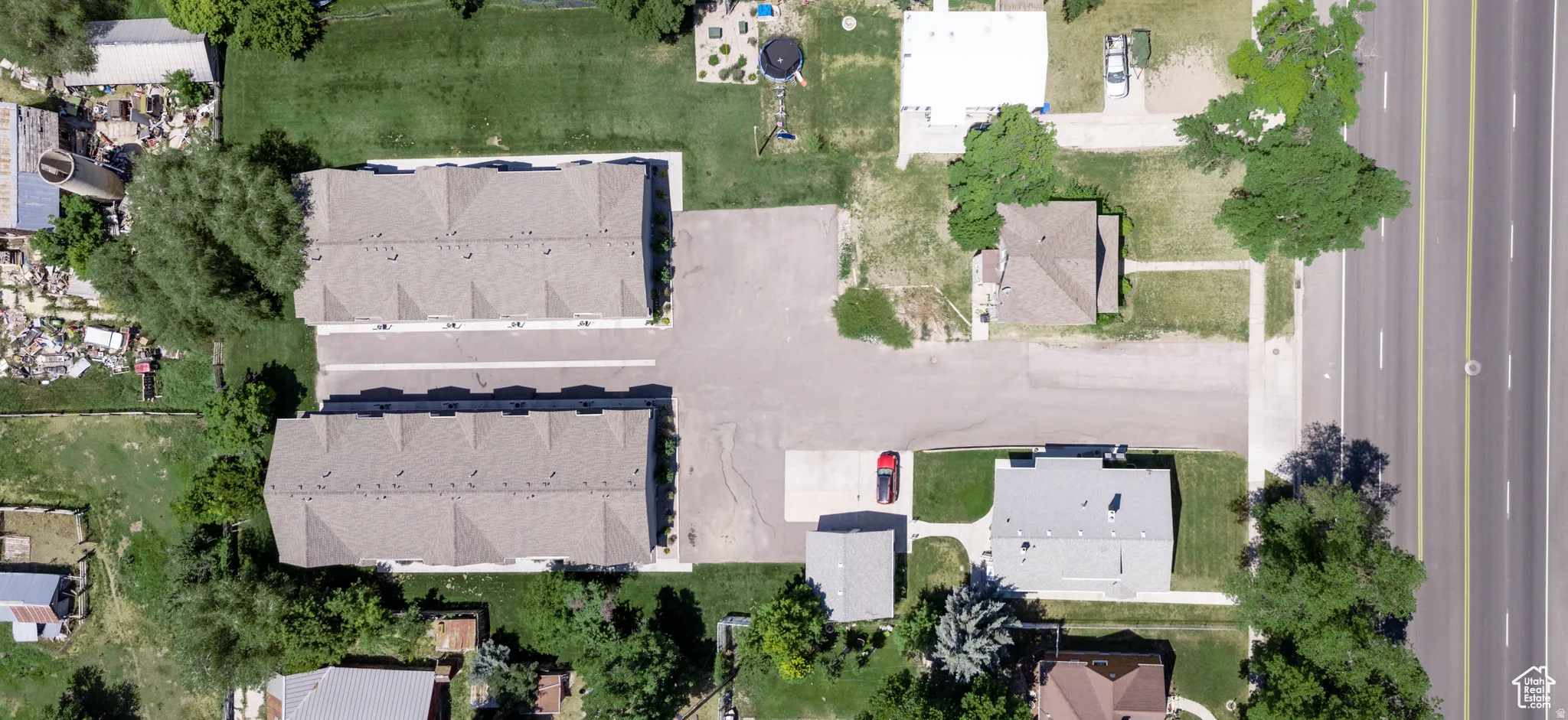 Property featuring two multi-unit buildings with shingle roofs, surrounded by green lawns